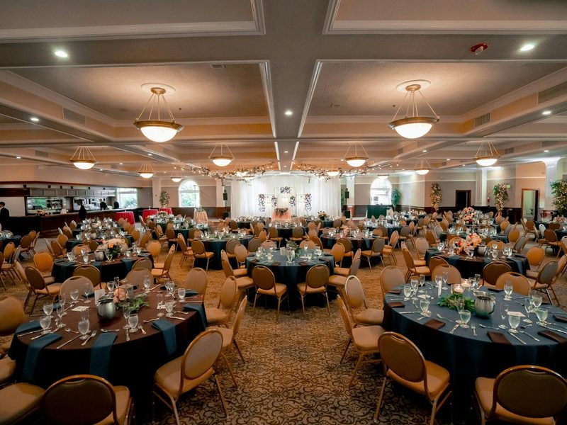Elegant ballroom with numerous tables prepared for a formal event