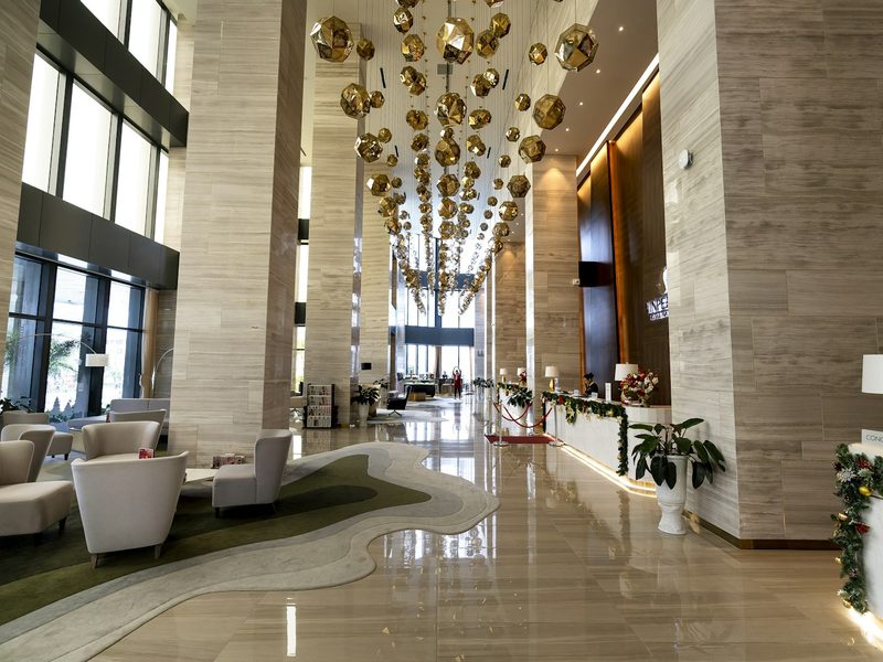 A hotel lobby with a chandelier hanging from the ceiling