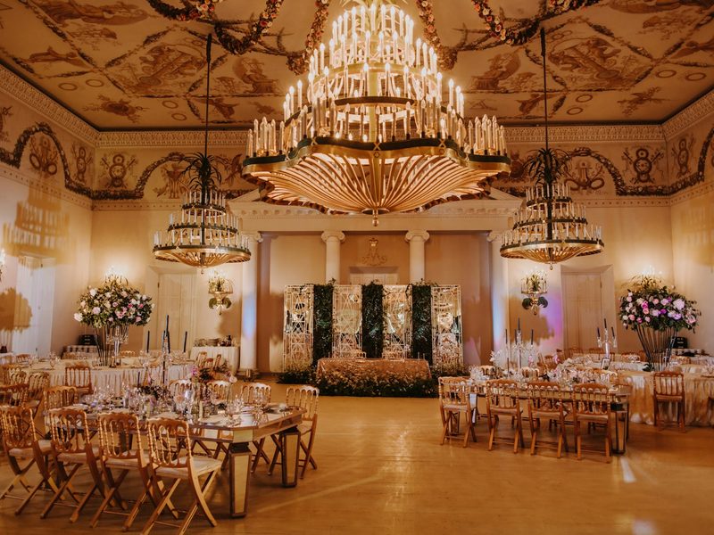 A banquet hall with chandeliers and tables