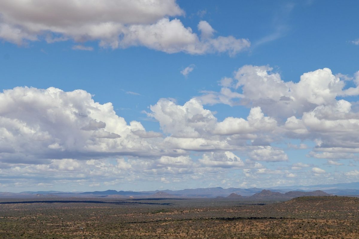 A view of a mountain range with clouds in the sky