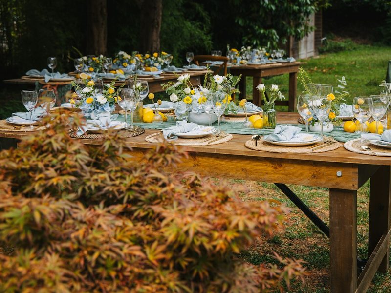 Outdoor tables set for a festive gathering with floral arrangements