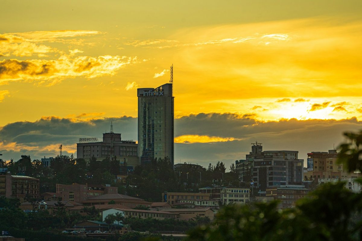 The sun is setting over a city with tall buildings