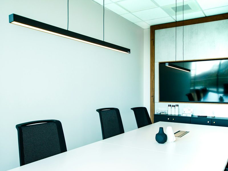 A conference room with a white table and black chairs