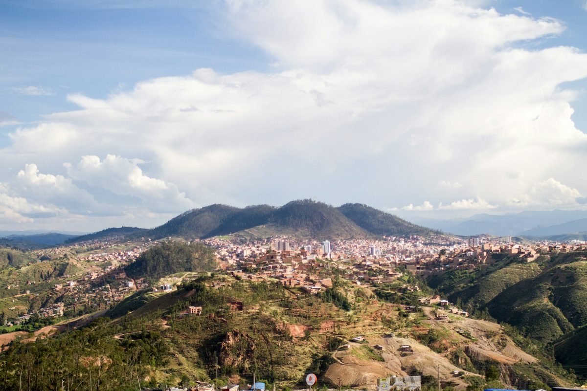 A sprawling city nestled in a valley between rolling hills