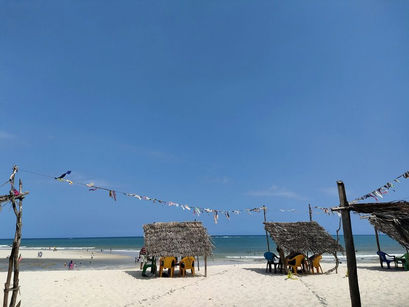 Sandy beach with loungers and thatched huts