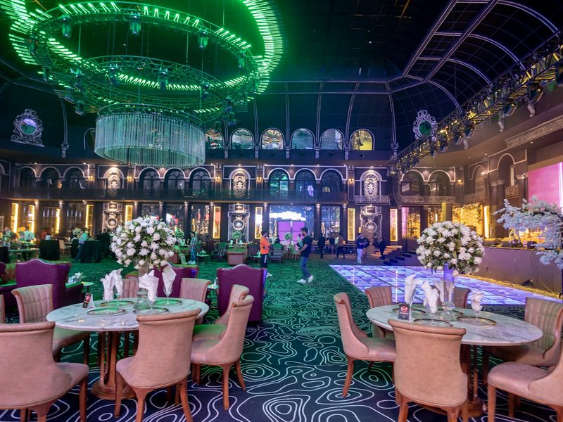 A fancy dining room with chandeliers and tables
