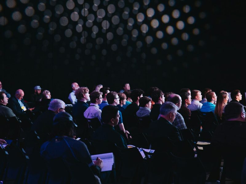 Crowd of people sitting on chairs inside room