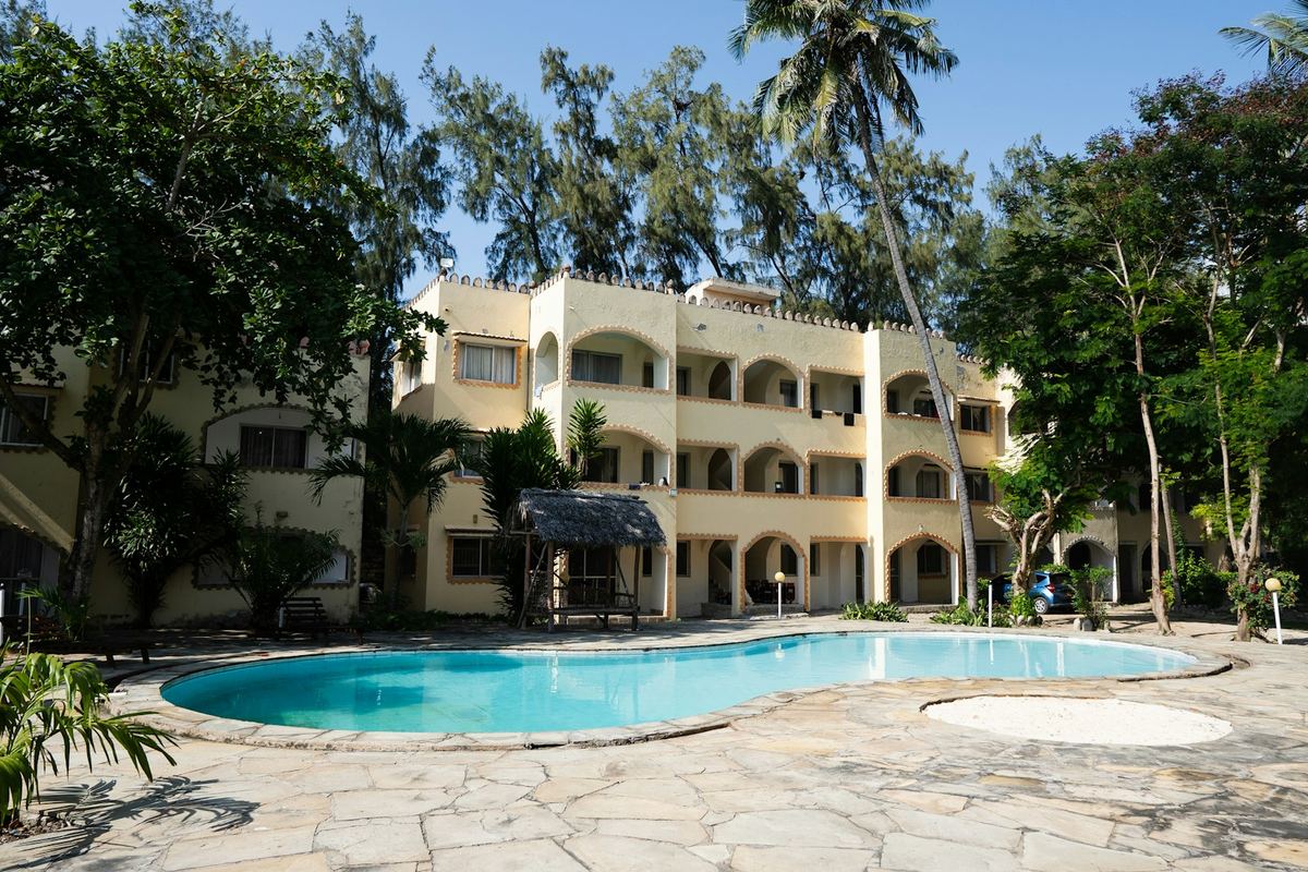 Resort building with pool and palm trees