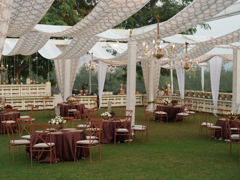 Elegant outdoor wedding reception with draped canopy and tables