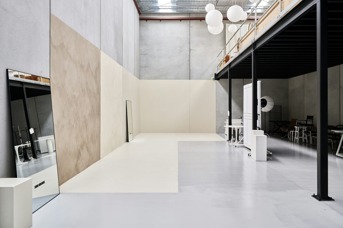 Industrial studio with concrete walls, a mezzanine and pendant lights