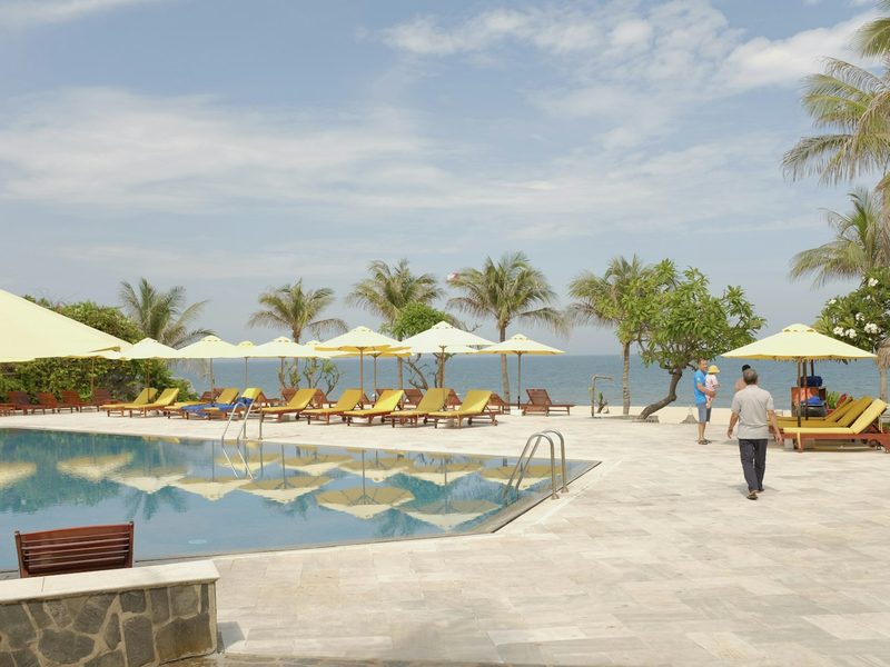 Tropical resort pool with lounge chairs and ocean view