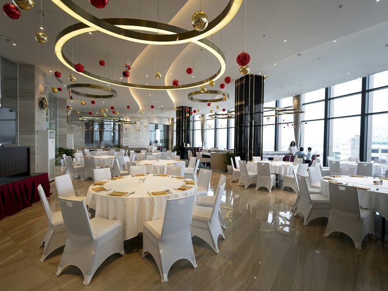 A banquet room with white tables and white chairs