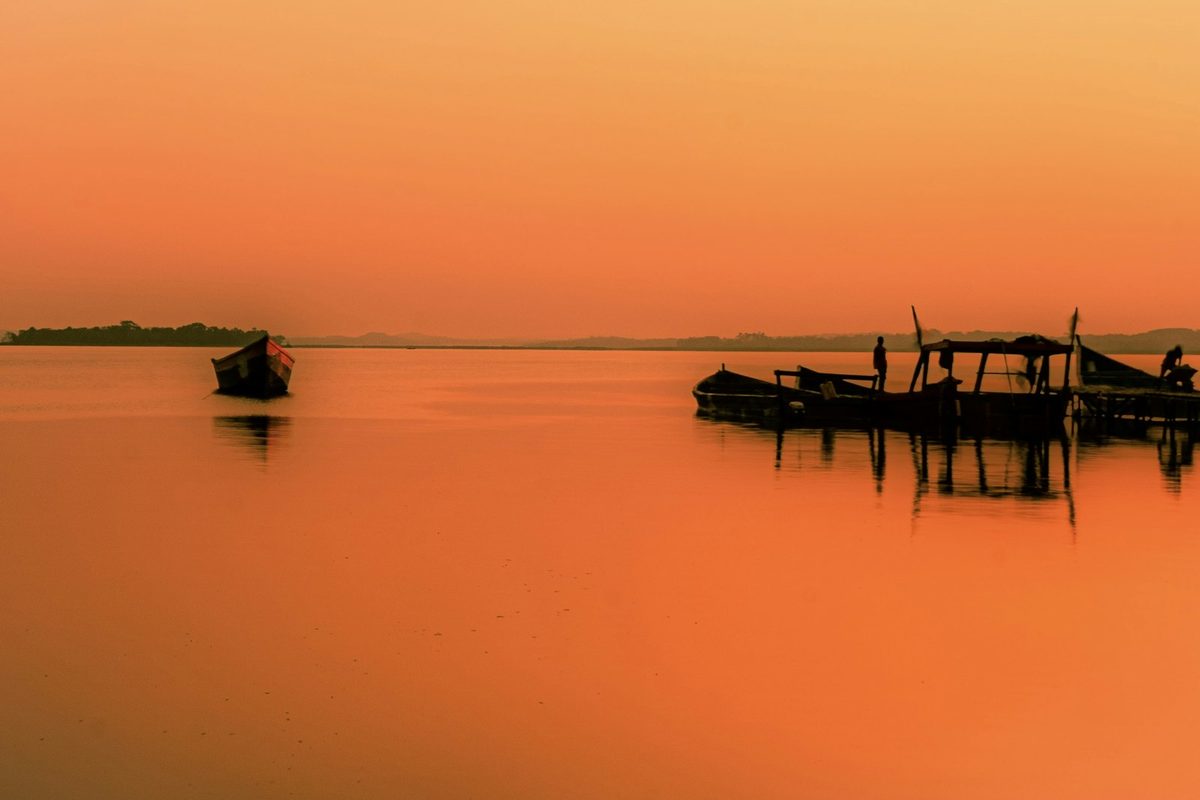 Silhouette of people riding boat on sea during daytime