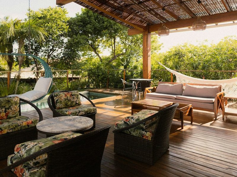 Covered patio with seating, hammock, and pool view