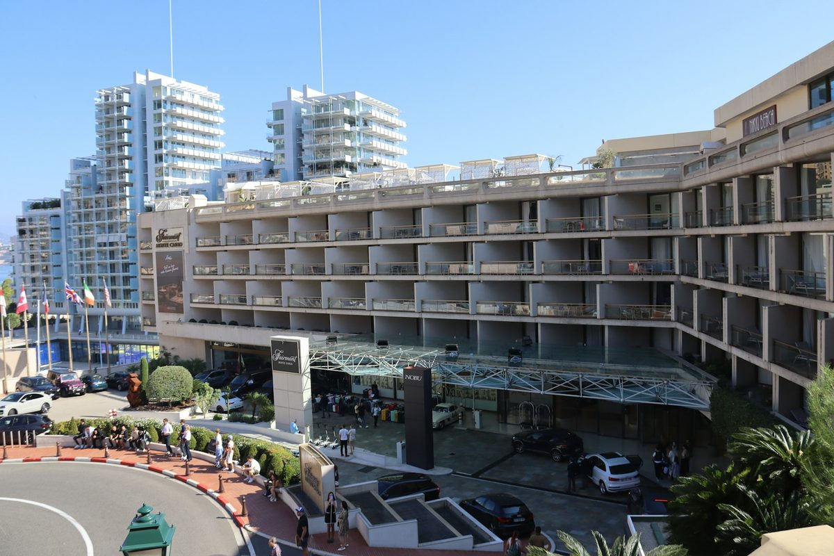 Modern hotel building with balconies and cityscape background apartments nearby